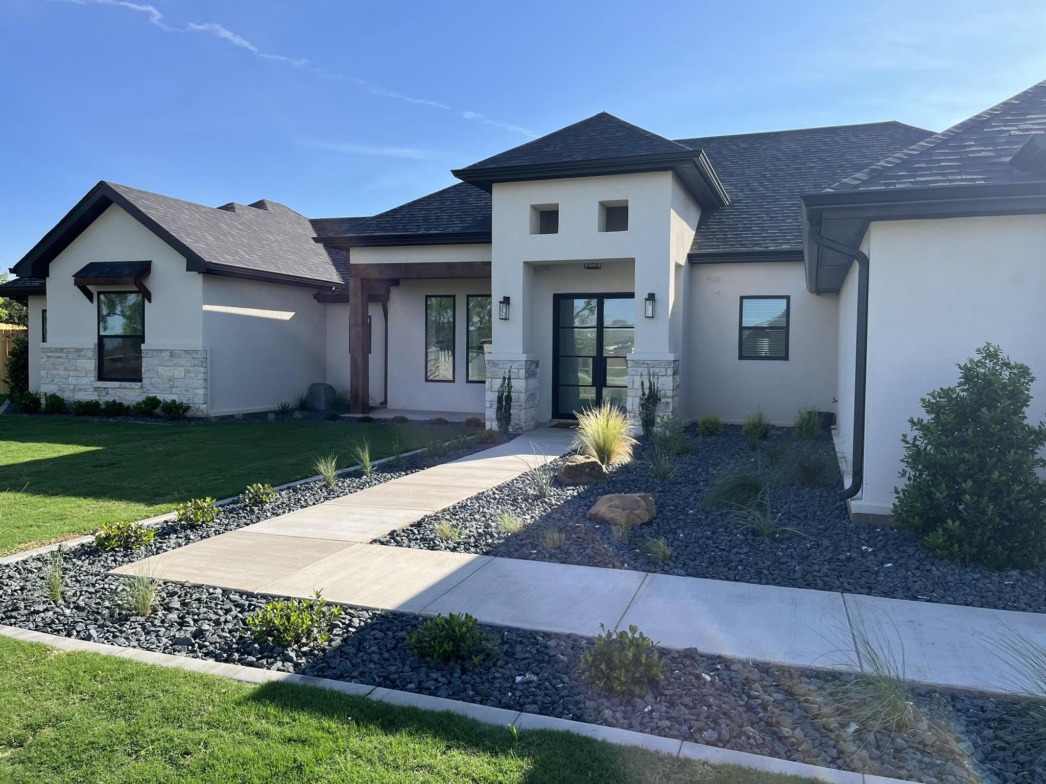 Landscaped home with a curving front walk, planting beds, and lawn
